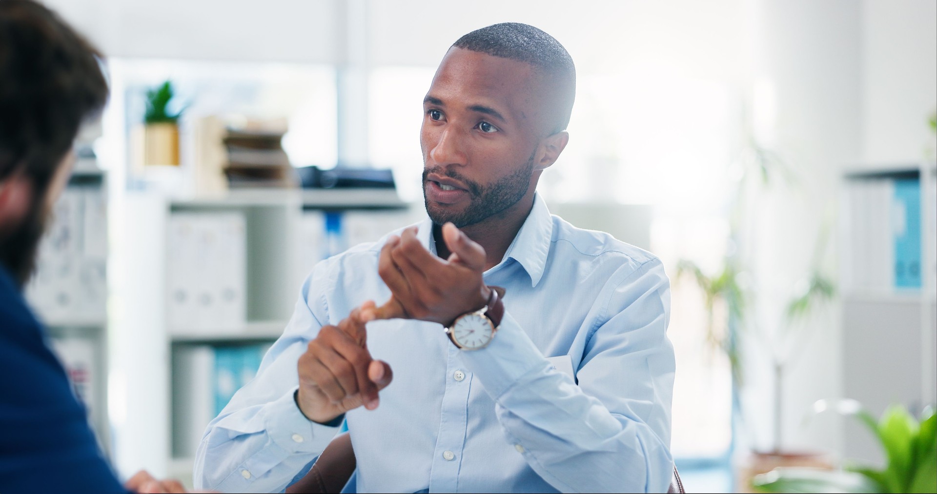 Business, black man and consultation with client, discussion and lens flare in office. Meeting, conversation and professional advisor planning, explain or communication for brainstorming work project